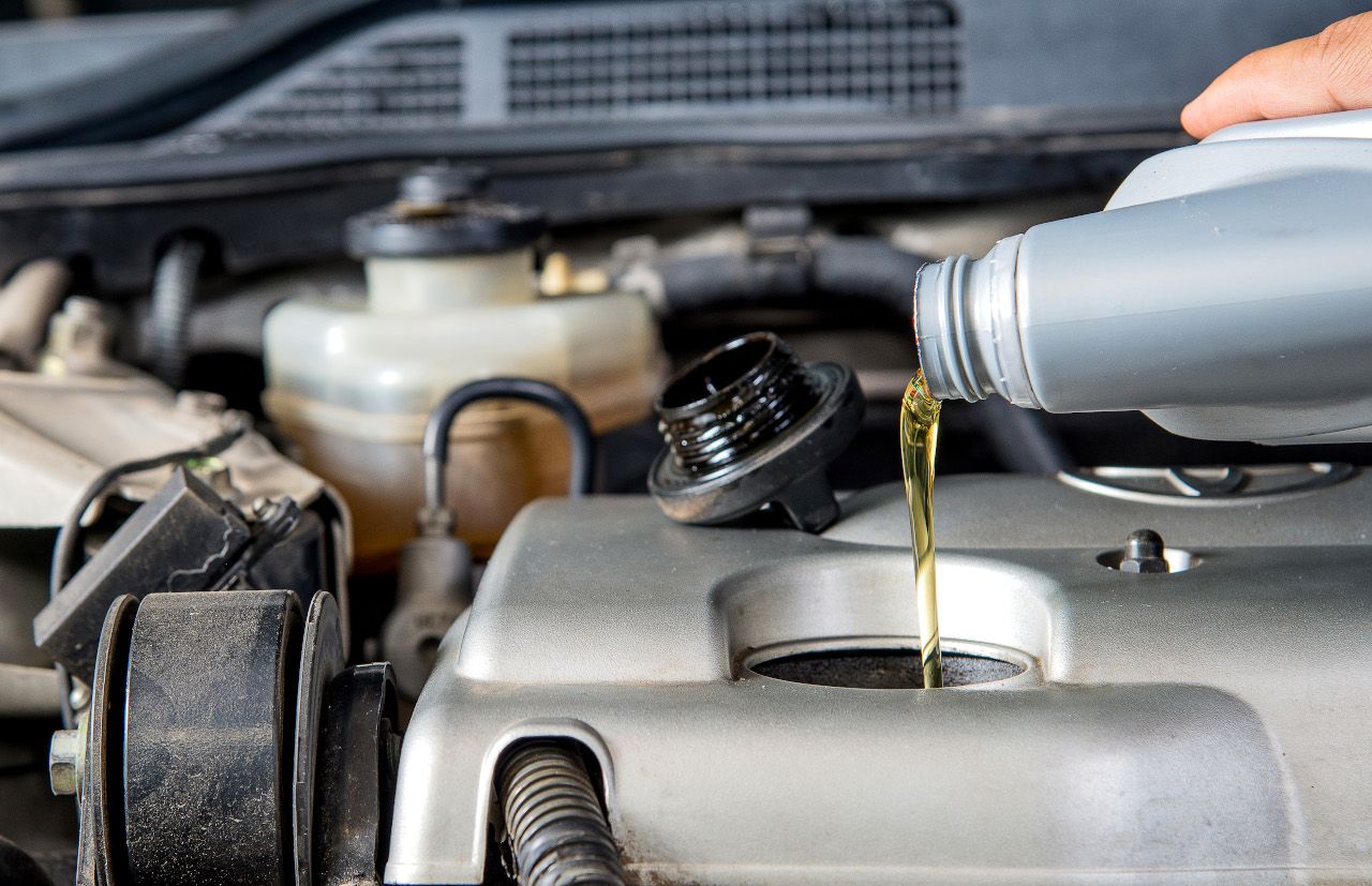 Öl wird aus Behälter in Motor gekippt