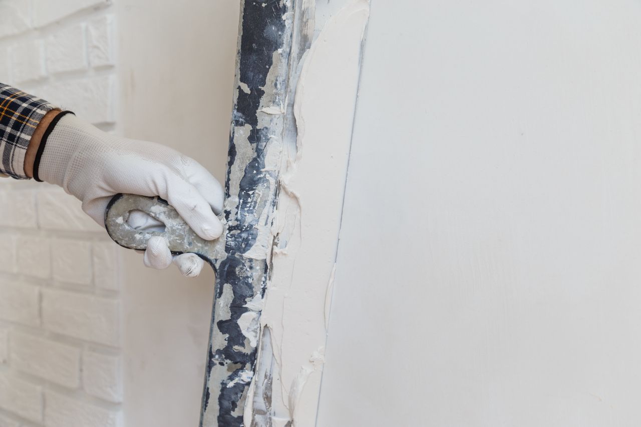 Maler schmiert Paste an die Wand